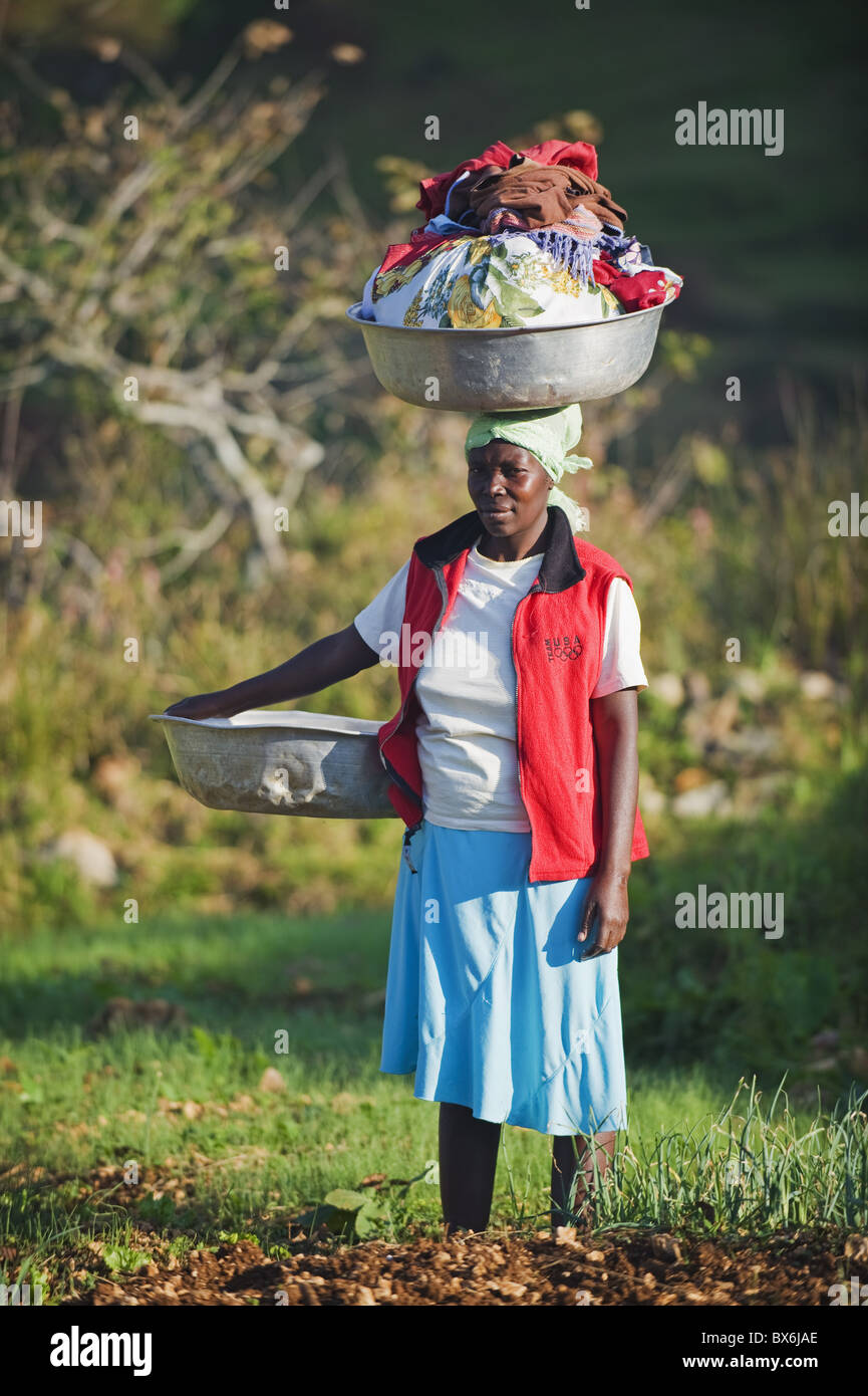 Eine Frau, die Wäsche auf dem Kopf, Kenscoff Bergen oberhalb von Port au Prince, Haiti, West Indies, Karibik, Mittelamerika Stockfoto