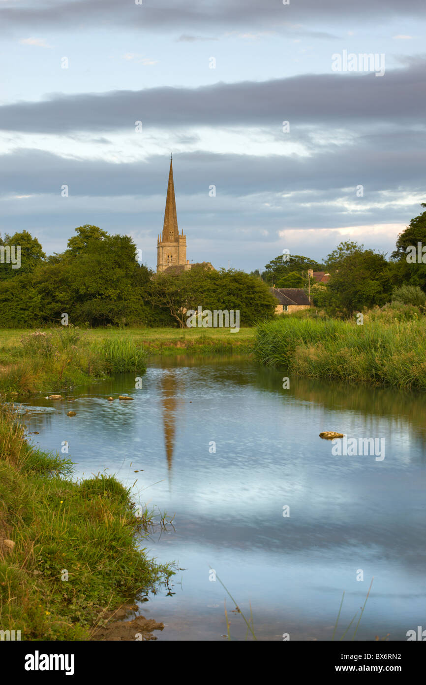 Burford Kirche Spire spiegelt sich in der River Windrush Watermeadows in den Cotswolds, Burford, Oxfordshire, England. Stockfoto