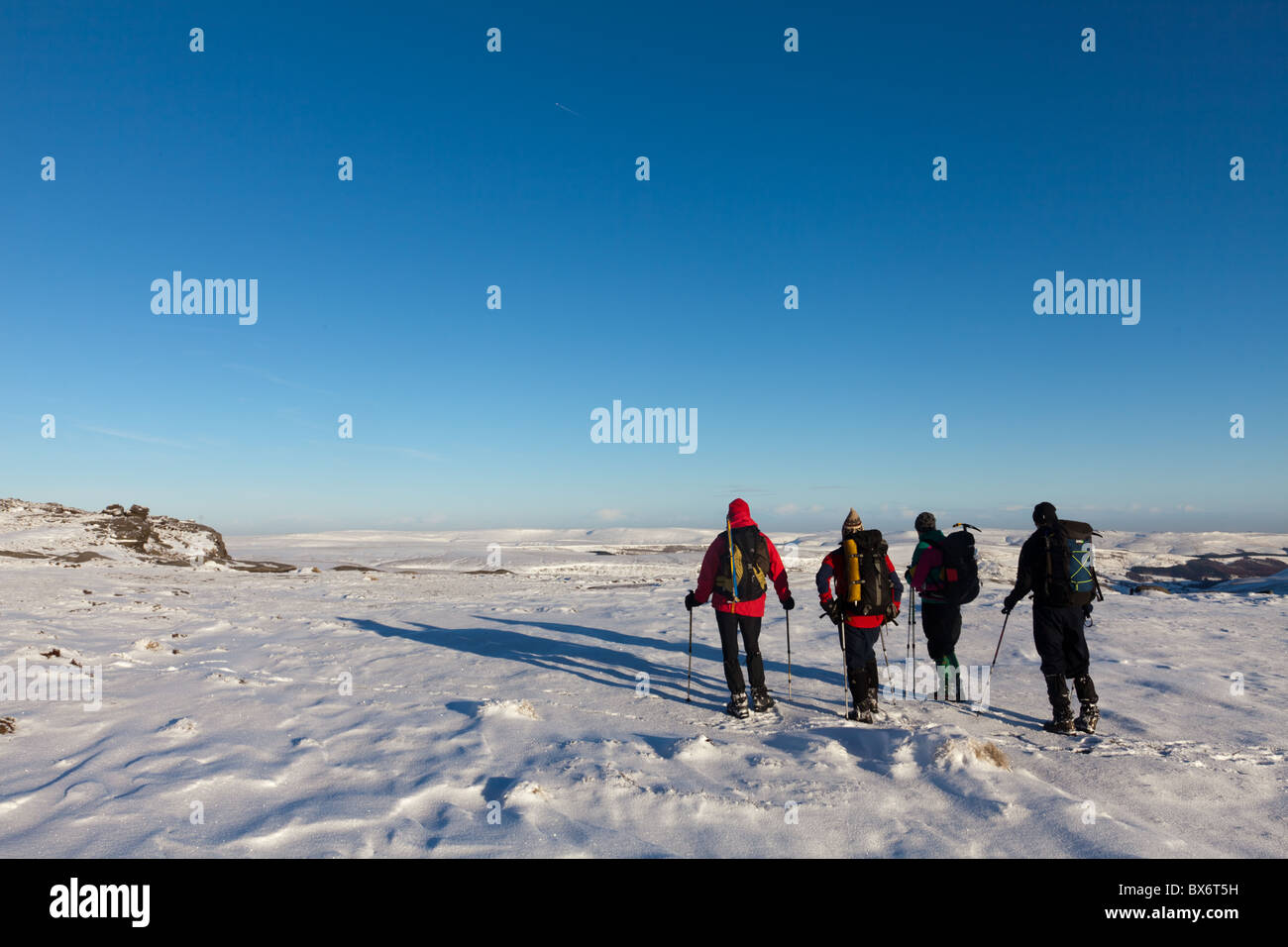 Wanderer im Winter auf Kinder Scout im Peak District National Park, mit Blick auf Bleaklow von Fairbrook Naze Derbyshire Stockfoto