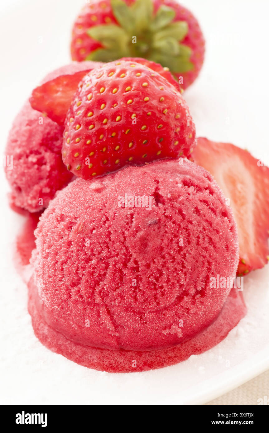 Erdbeereis mit Erdbeeren als Closeup auf einem weißen Teller Stockfoto