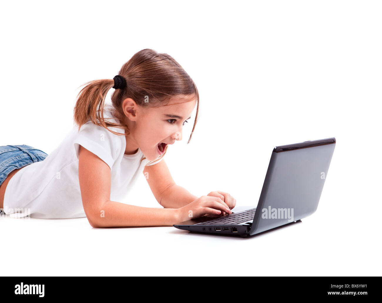 Kleines Mädchen auf Boden mit einem Laptop arbeiten Stockfoto
