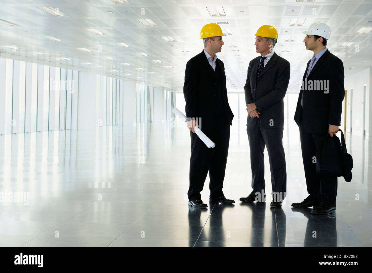 Drei Führungskräfte in Streetware im leeren Büroflächen Stockfoto