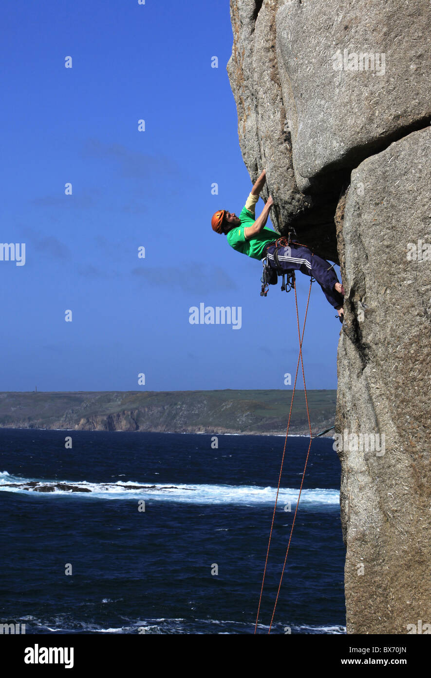 Ein Bergsteiger packt einen schwierigen Überhang auf Klippen in der Nähe von Sennen Cove, einem beliebten Rock Klettergebiet bei Lands End, Cornwall, UK Stockfoto