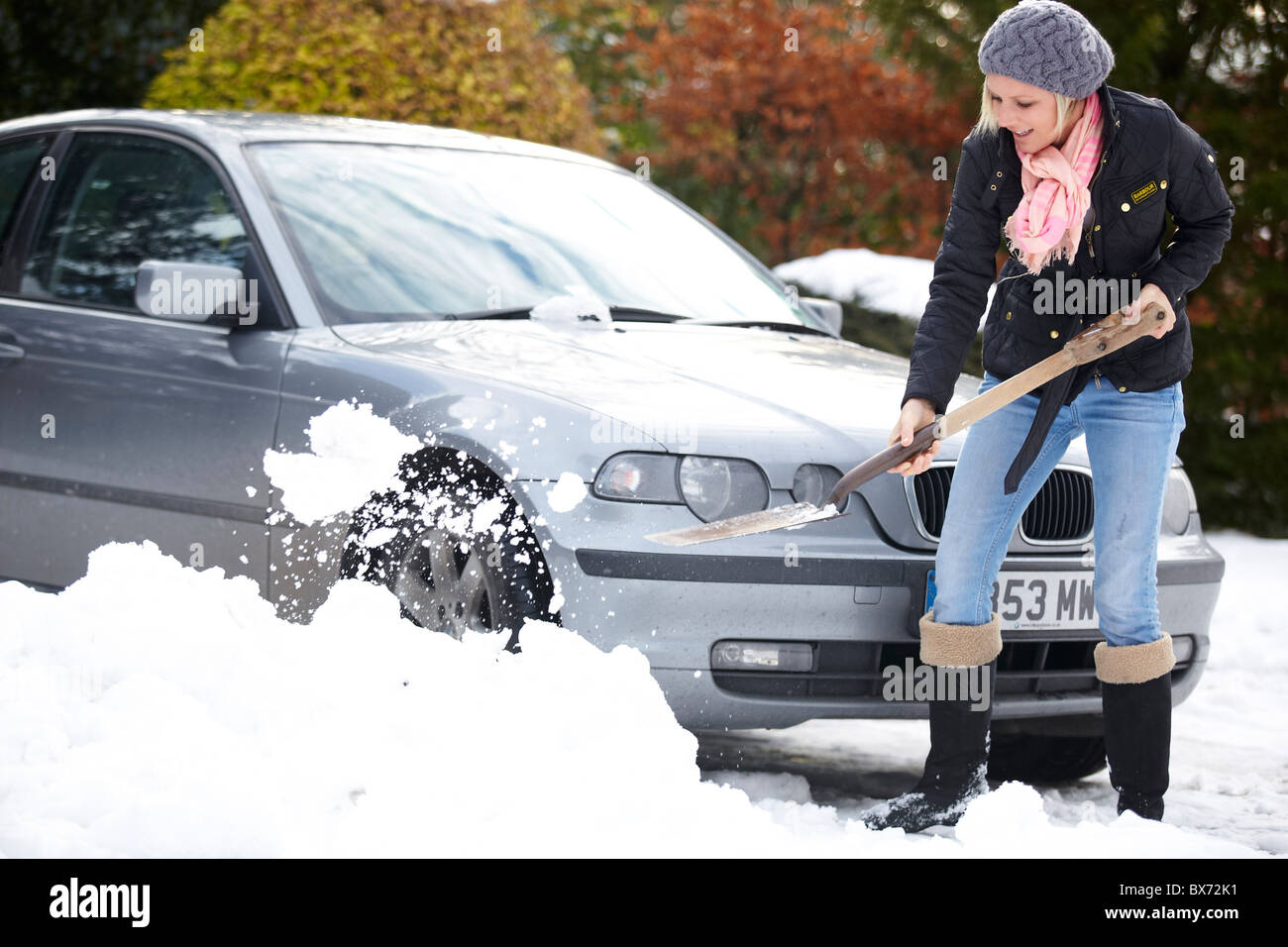 Frau aus dem Auto aus dem Schnee Graben Stockfoto