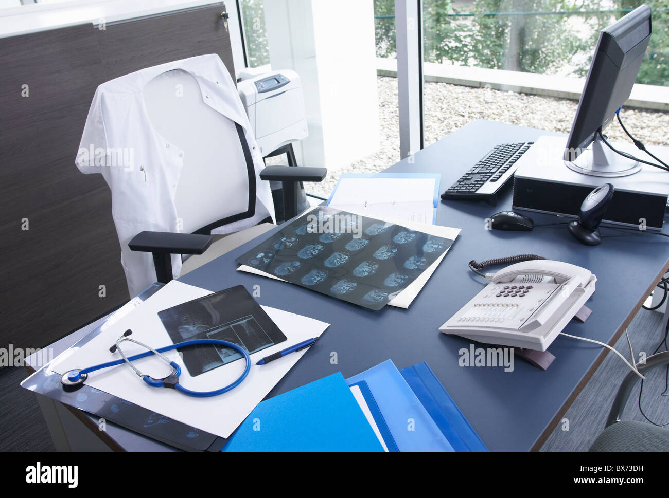 Schreibtisch, Röntgenstrahlen & Stethoskop des Arztes Stockfoto