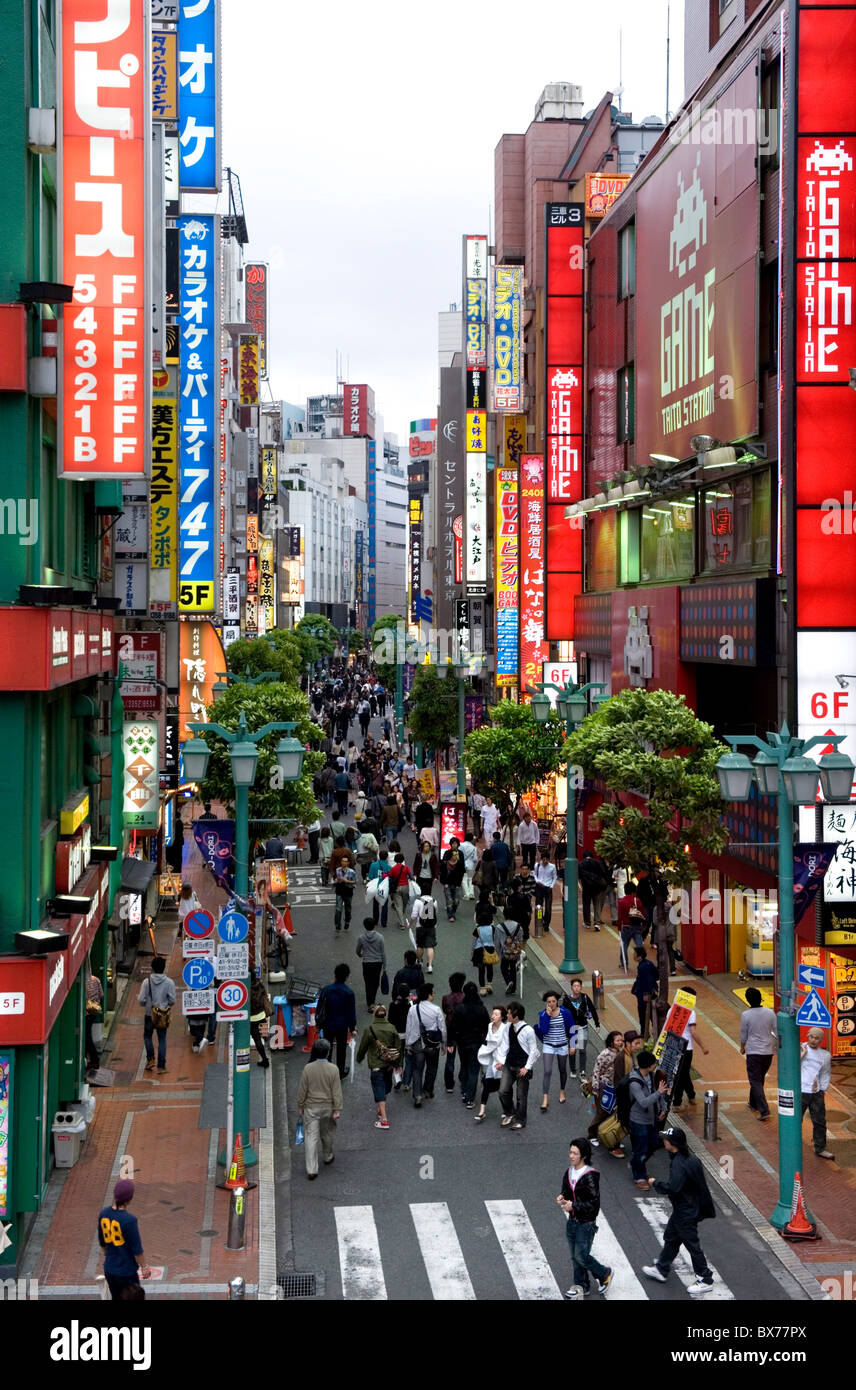 Eine Fußgängerzone, gesäumt von Geschäften und Schilder zieht ein Publikum in Shinjuku, Tokio, Japan, Asien Stockfoto