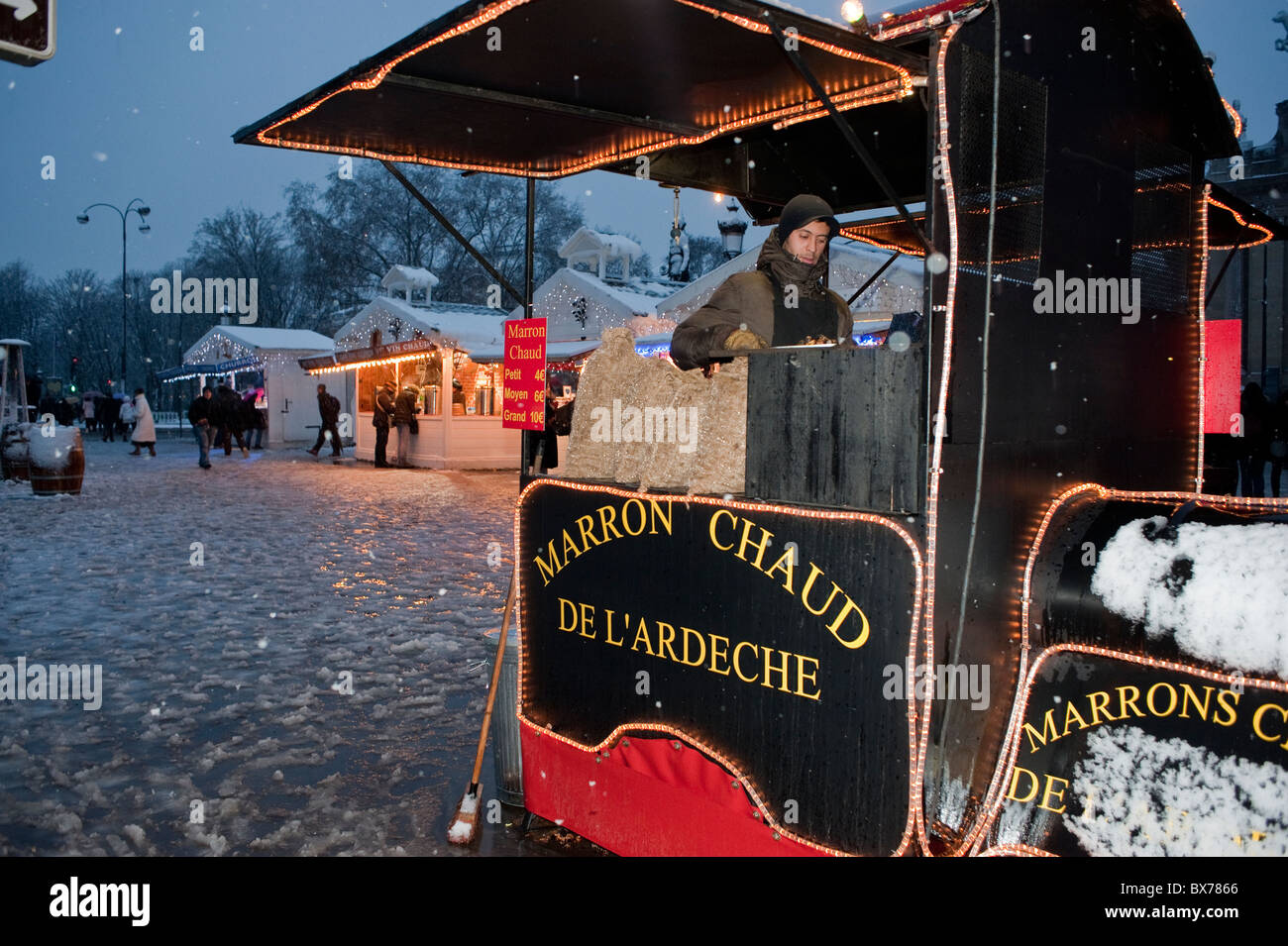 Paris, Frankreich, man Selling Warm Chestnuts, Teen Street Food Vendor, auf dem französischen Weihnachtsmarkt, auf den Champs-Elysees, Winter, Nachtarbeit Stockfoto