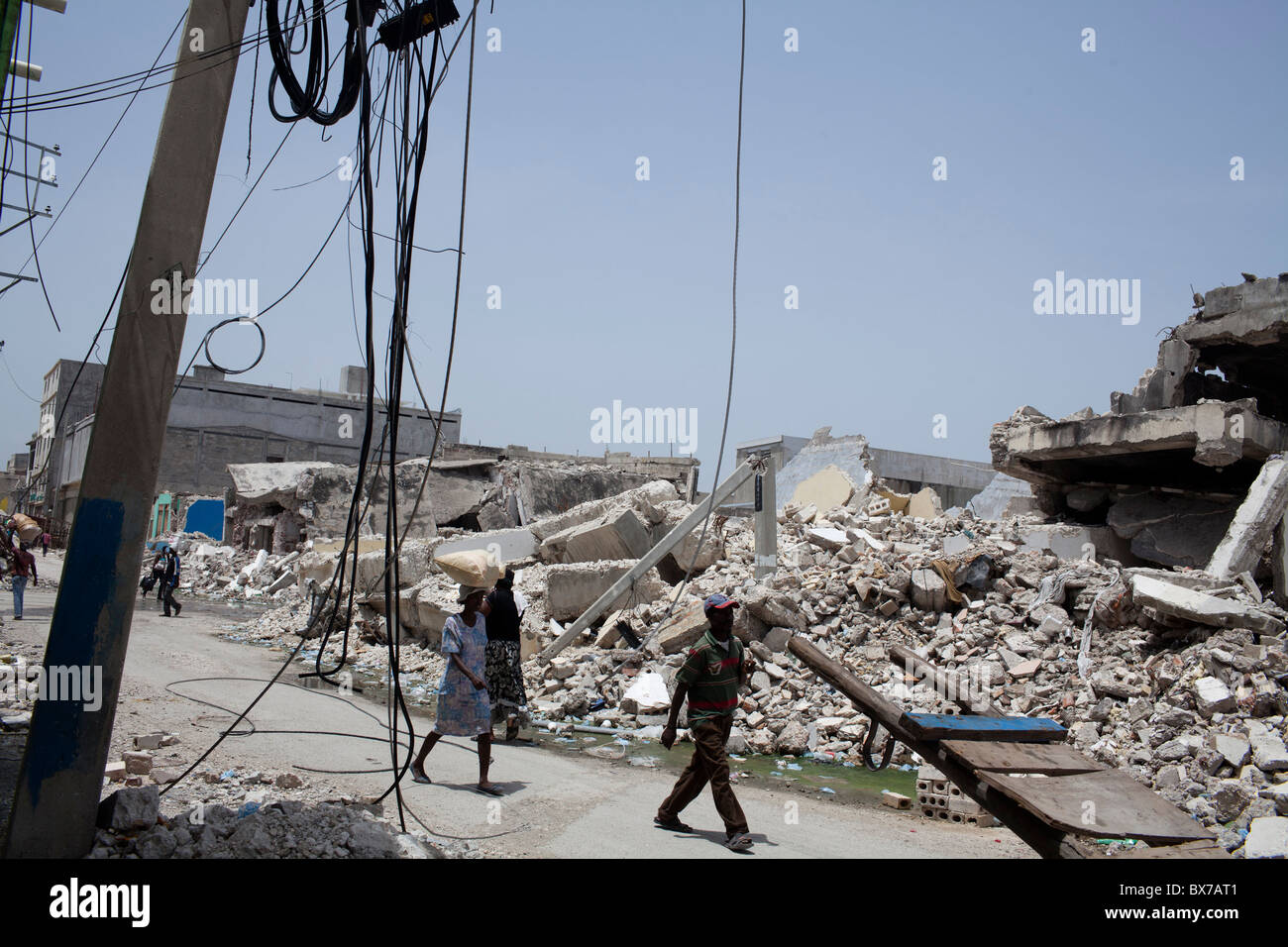 Fußgänger schlendern Sie vorbei an riesigen Haufen von Erdbeben Schutt am 8. Juli 2010 in Port-au-Prince, Haiti. Stockfoto