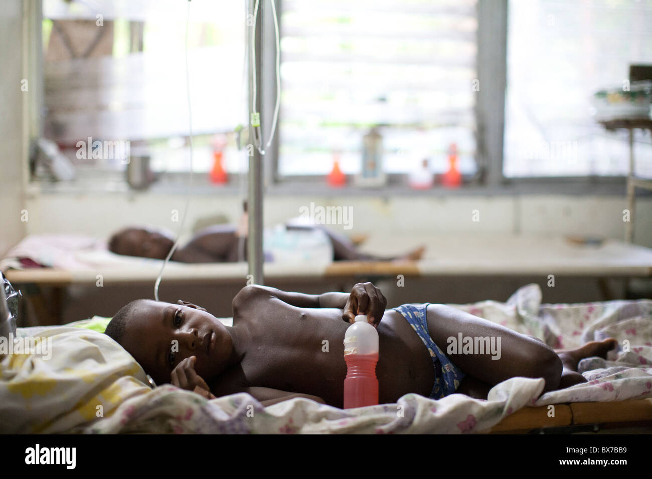 Ein Junge Cholera-Patienten liegt auf einem Feldbett in das Hospital Albert Schweitzer auf Donnerstag, 28. Oktober 2010 in Deschapelles, Haiti. Stockfoto