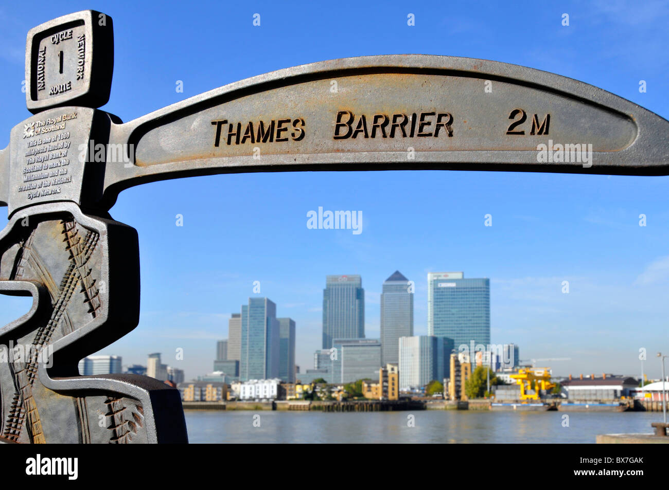 Riverside Promenade Wegweiser auf Greenwich Peninsula ist auch Teil des National Cycle Network mit Canary Wharf skyline über London England Großbritannien Stockfoto