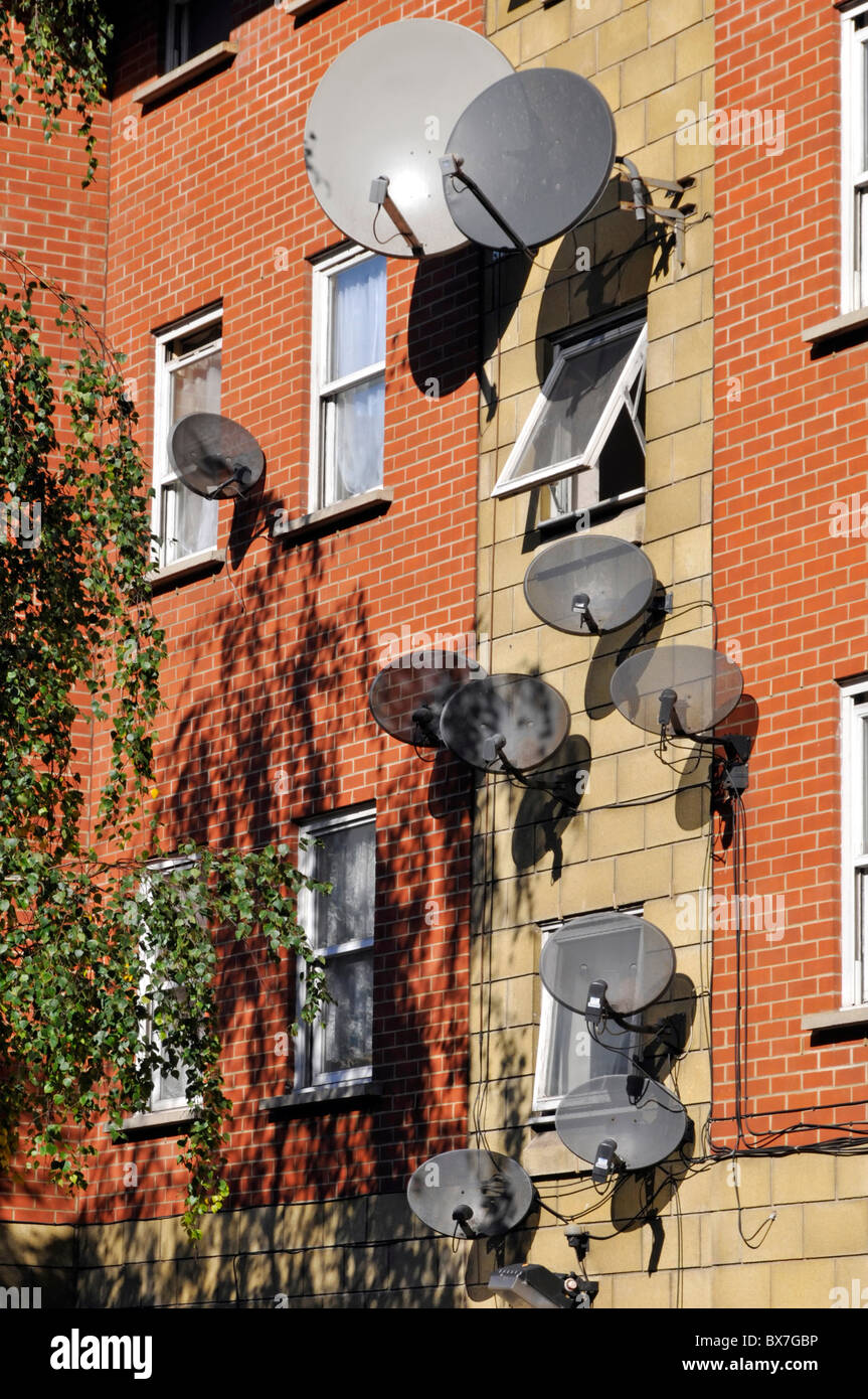 Große Cluster der Wand montiert Satelliten-TV-Antenne Gericht Installationen einschließlich Sky-TV Antennen an der Seite des Wohnhauses South London England Großbritannien Stockfoto