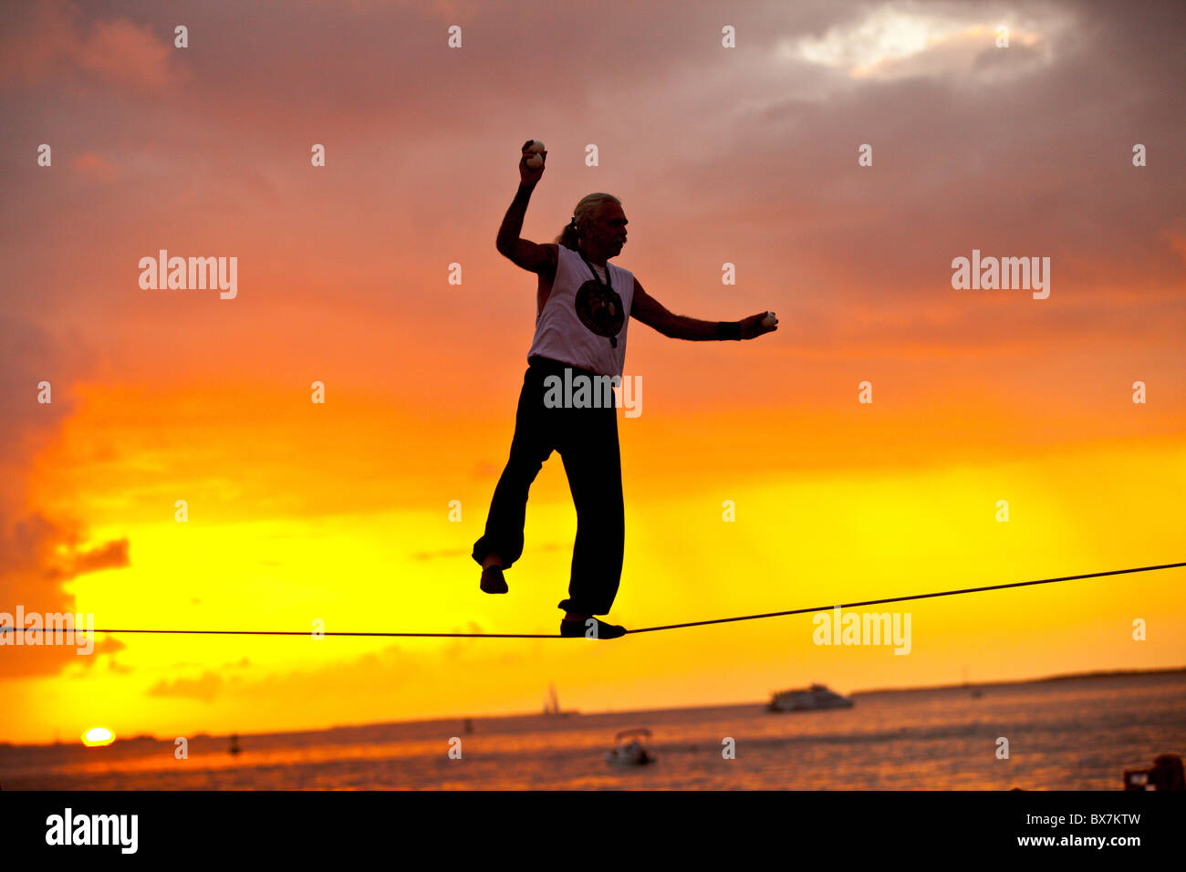 Der Straßenkünstler will Soto spielt seinen Drahtseilakt während der Sunset-Tour am Mallory Square in Key West, Florida. Stockfoto