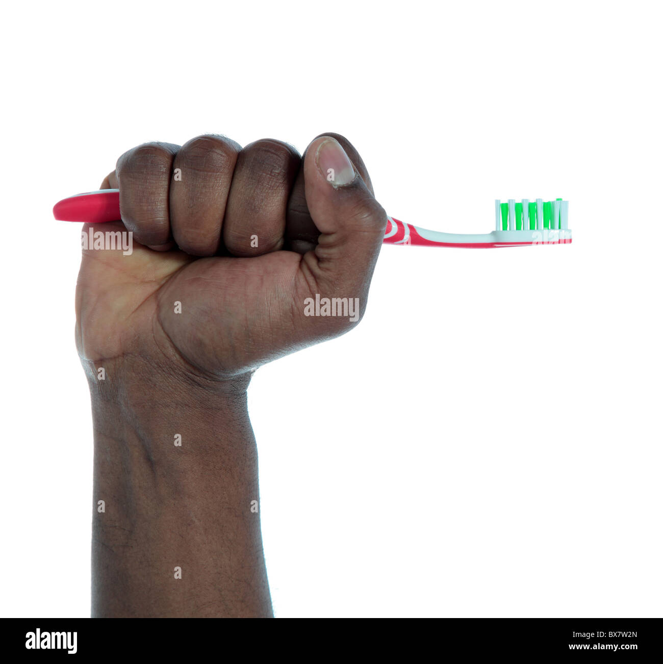 Eine dunkel-enthäutete Hand mit einer Zahnbürste. Alle auf weißem Hintergrund. Stockfoto
