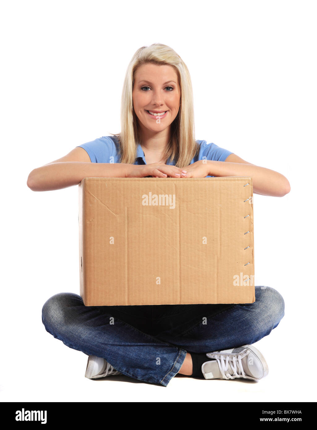 Attraktive junge Frau am Boden halten Umzugskarton. Alle auf weißem Hintergrund. Stockfoto