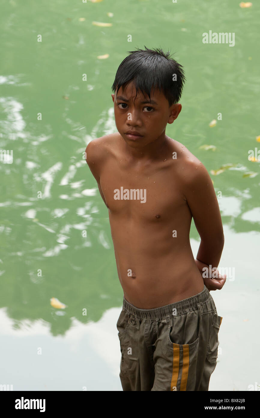 Ein Filipino junge steht in der Nähe von einem Teich nach dem Schwimmen. Stockfoto