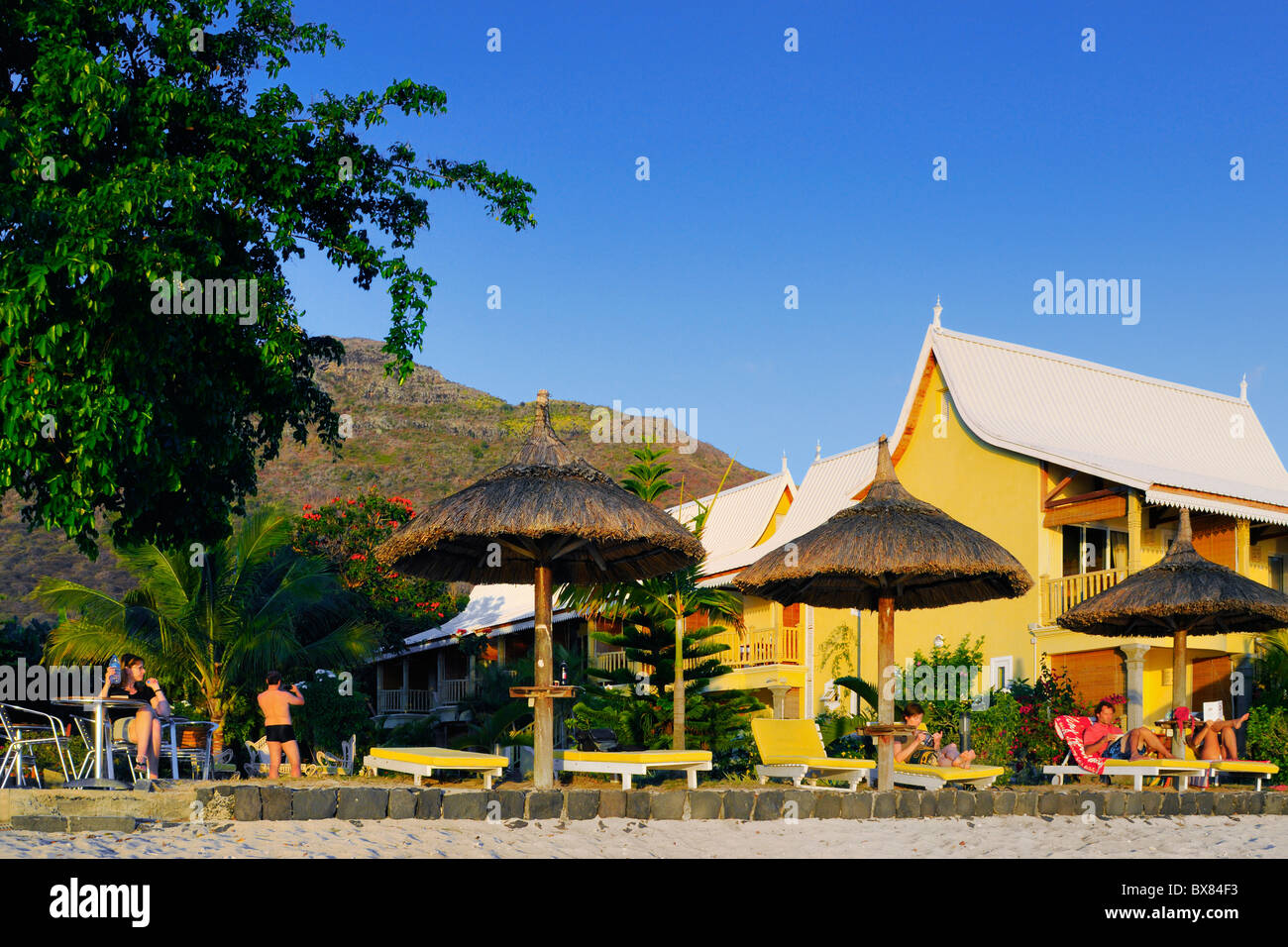 Genießen Sie einen Sonnenuntergang am Strand vorne und Garten in einem Hotel in La Preneuse, Black River, Mauritius. Stockfoto