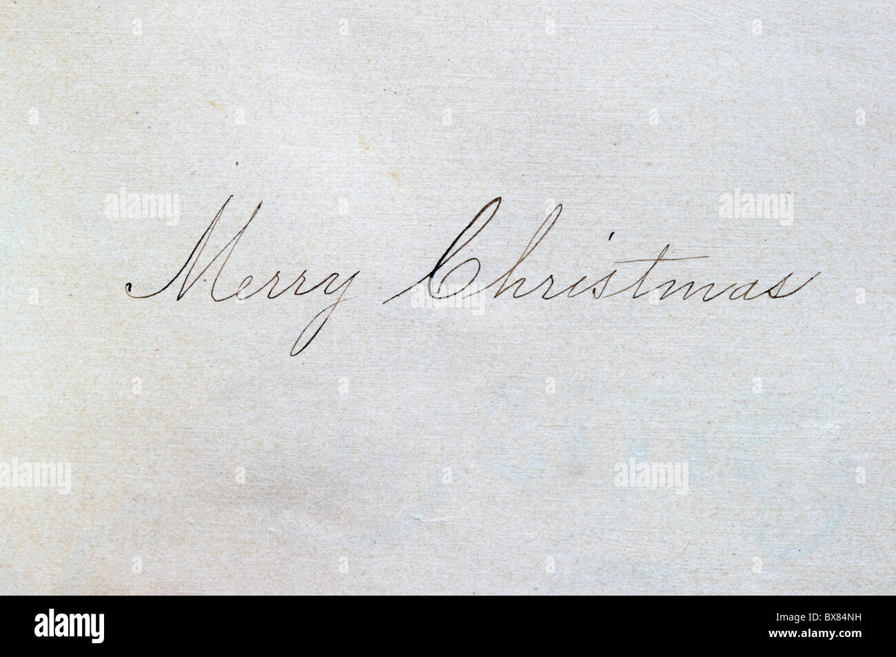 Frohe Weihnachten in Kursivschrift auf Papier geschrieben, mit einem Kugelschreiber Stockfoto