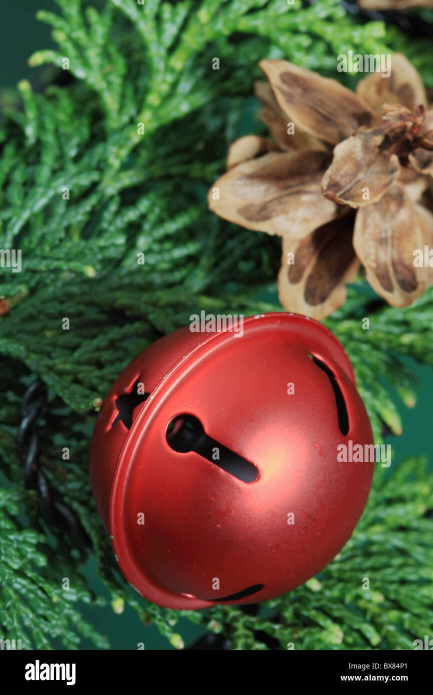 Rot Weihnachten Bell auf grün mit Tannenzapfen im Hintergrund und selektiven Fokus Stockfoto