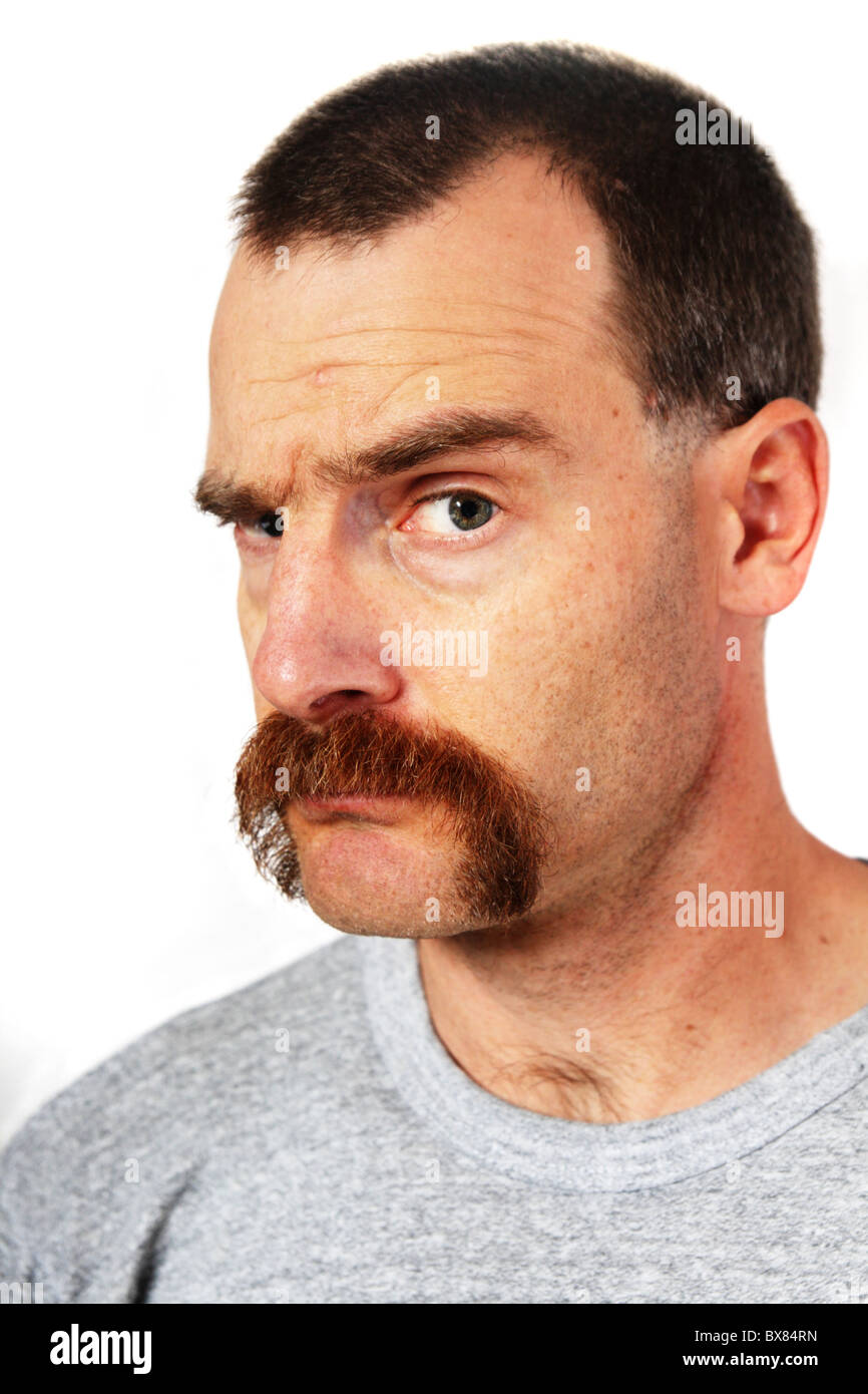 ein Mann mit einem großen Schnurrbart schaut den Betrachter an und hebt eine Augenbraue Stockfoto