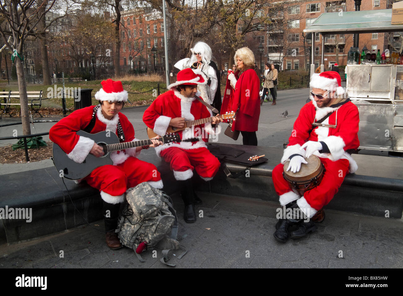 New York ny Weihnachtsmänner spielen in Washington Square Park während santacon Stockfoto