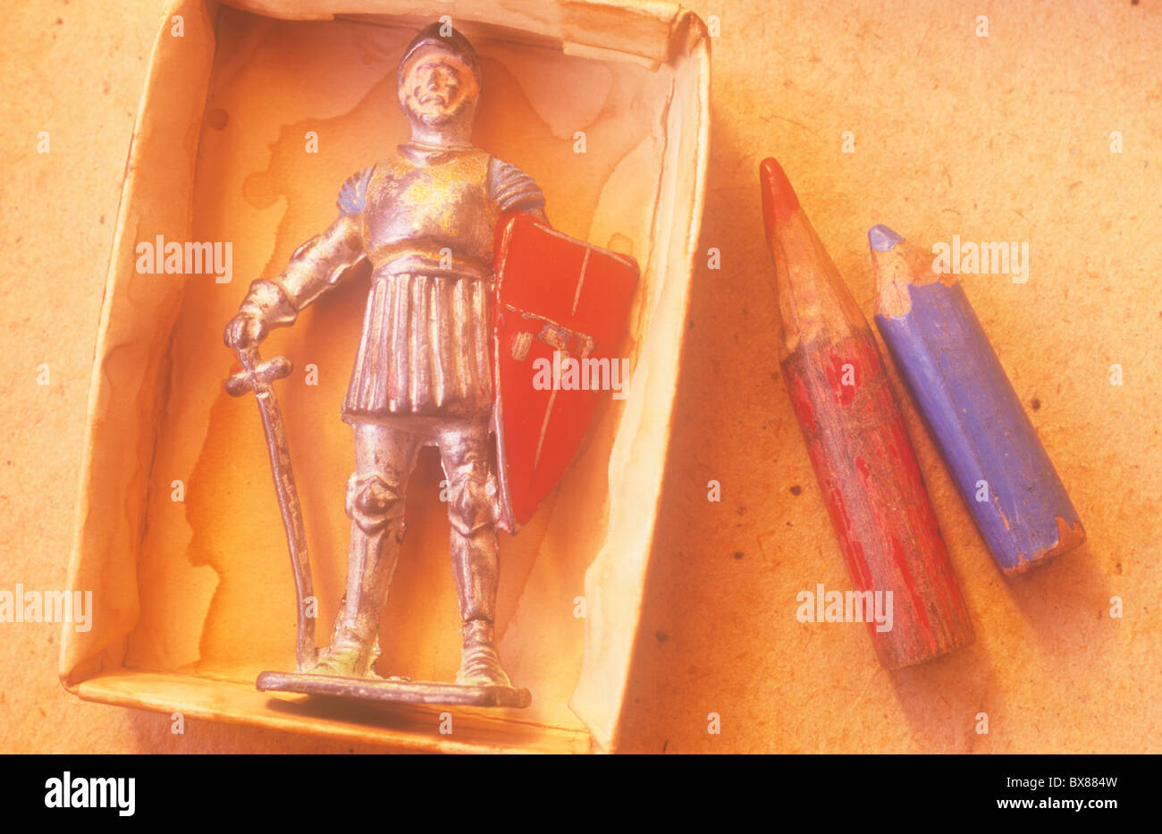 Nahaufnahme von zerkratzten Metall Blei Modell der Ritter in Rüstung mit Schwert und Schild im Karteneinschub neben zwei Bleistift stubs Stockfoto