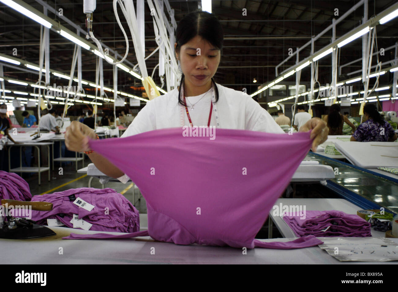 Ein Arbeiter überprüft ein Kleidungsstück in der Bekleidungsfabrik der United International Corp. In San Antonio, Saipan, Mittwoch, den 16. März 2005. Stockfoto