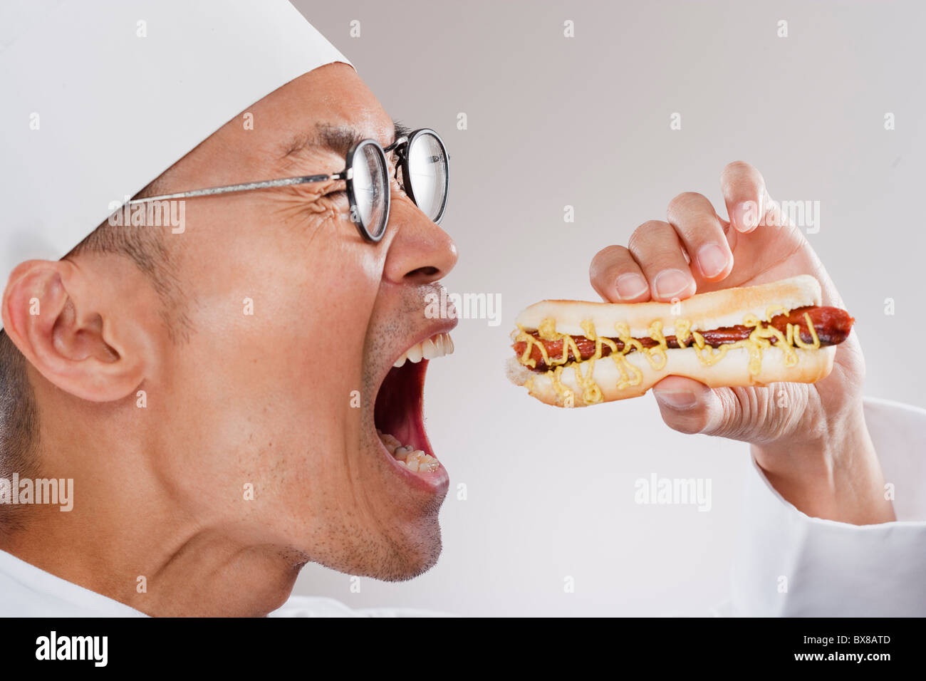 Koch, ein Hot Dog Essen Stockfoto