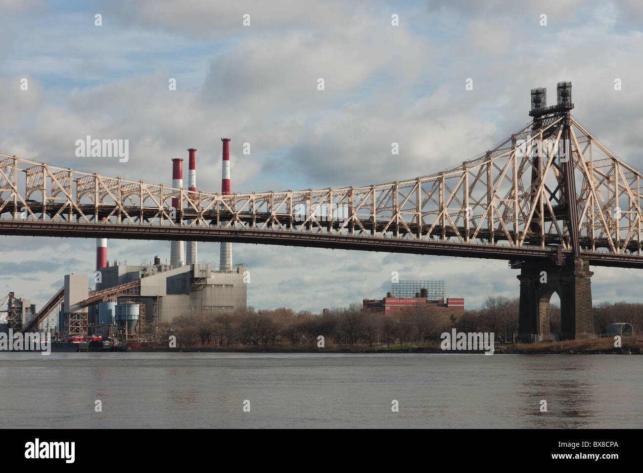 Die Queensboro Brücke überspannt den East River mit Ravenswood Generating Station in New York City im Hintergrund. Stockfoto