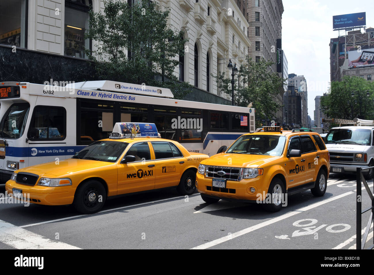 Hybrid-Elektro-Busse neben New York yellow Cab, Manhattan Stockfoto
