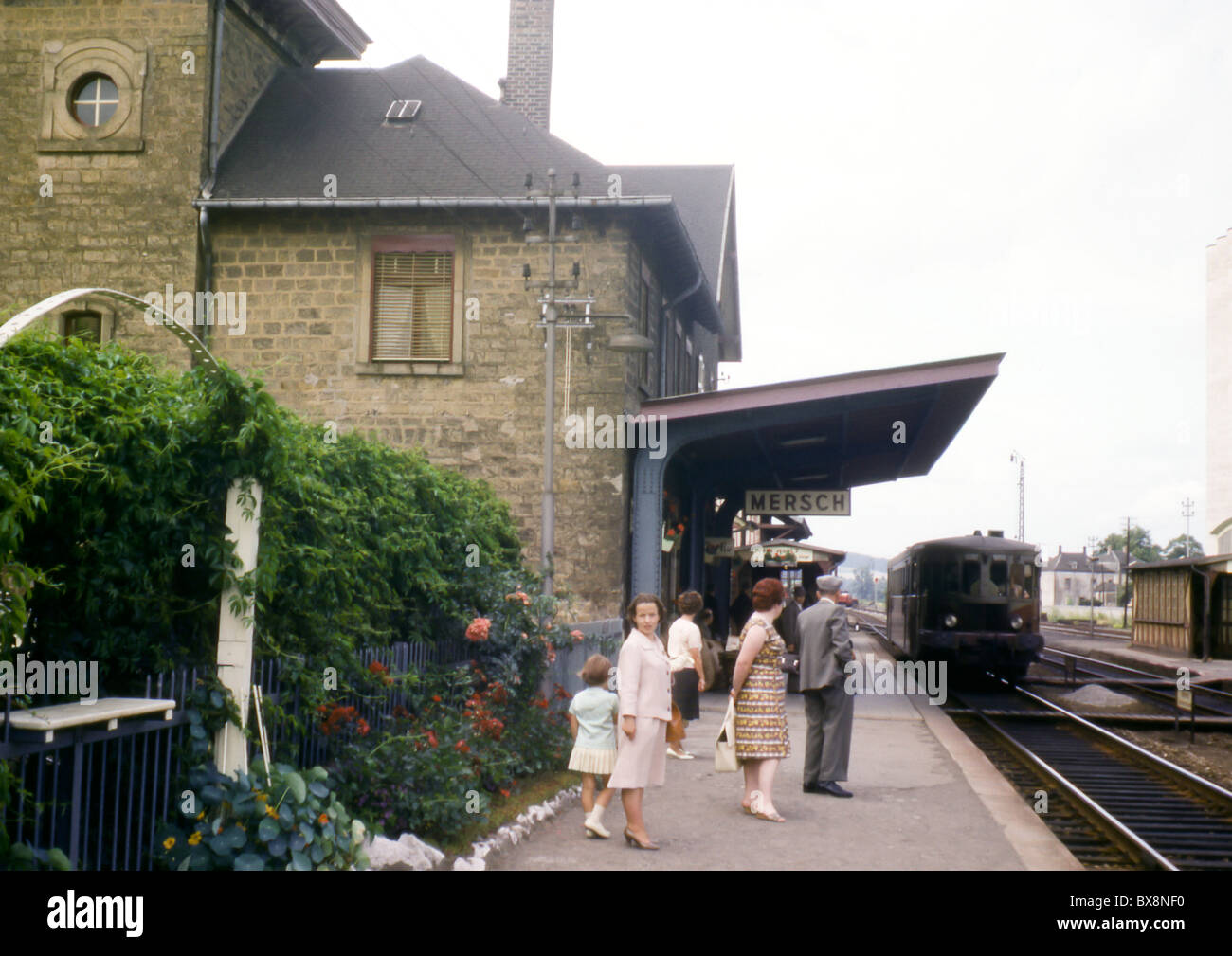 Ein 60er Jahre Bild der Passagiere warten auf der herannahende Zug am Mersch Bahnhof, Luxemburg. Stockfoto