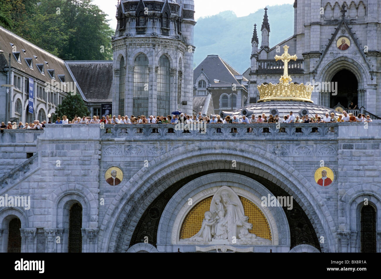 Touristen, die an den Wänden der Rosenkranz-Basilika in Lourdes, Frankreich. Stockfoto