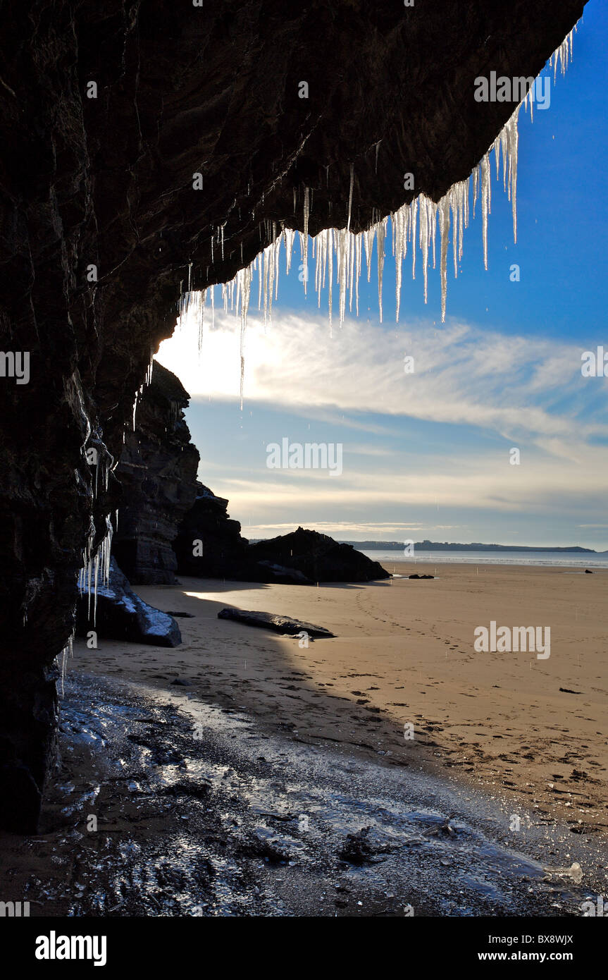 Eiszapfen hängen von den Klippen oberhalb einer Höhle am Watergate Bay, North Cornwall Stockfoto