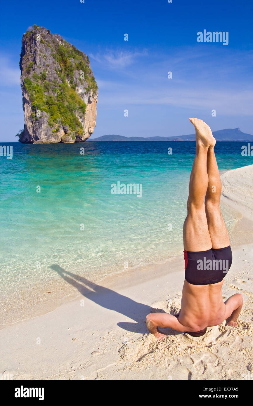 Männliche Handstand am Strand Stockfoto