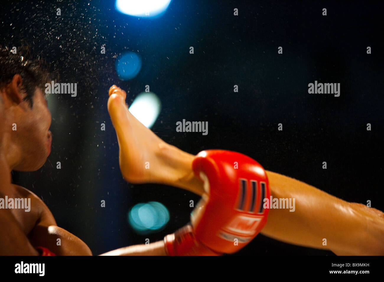 Kick mit Kopf des Muay thai Kickboxer senden von Schweiß durch die Luft fliegen Stockfoto
