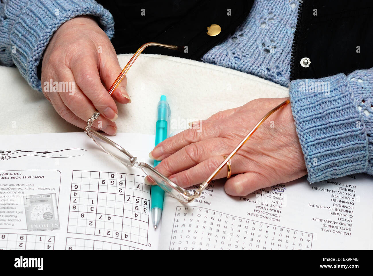 83 Jahre alte Rentnerin mit Puzzle-Buch, Brille und Stift-England-uk Stockfoto