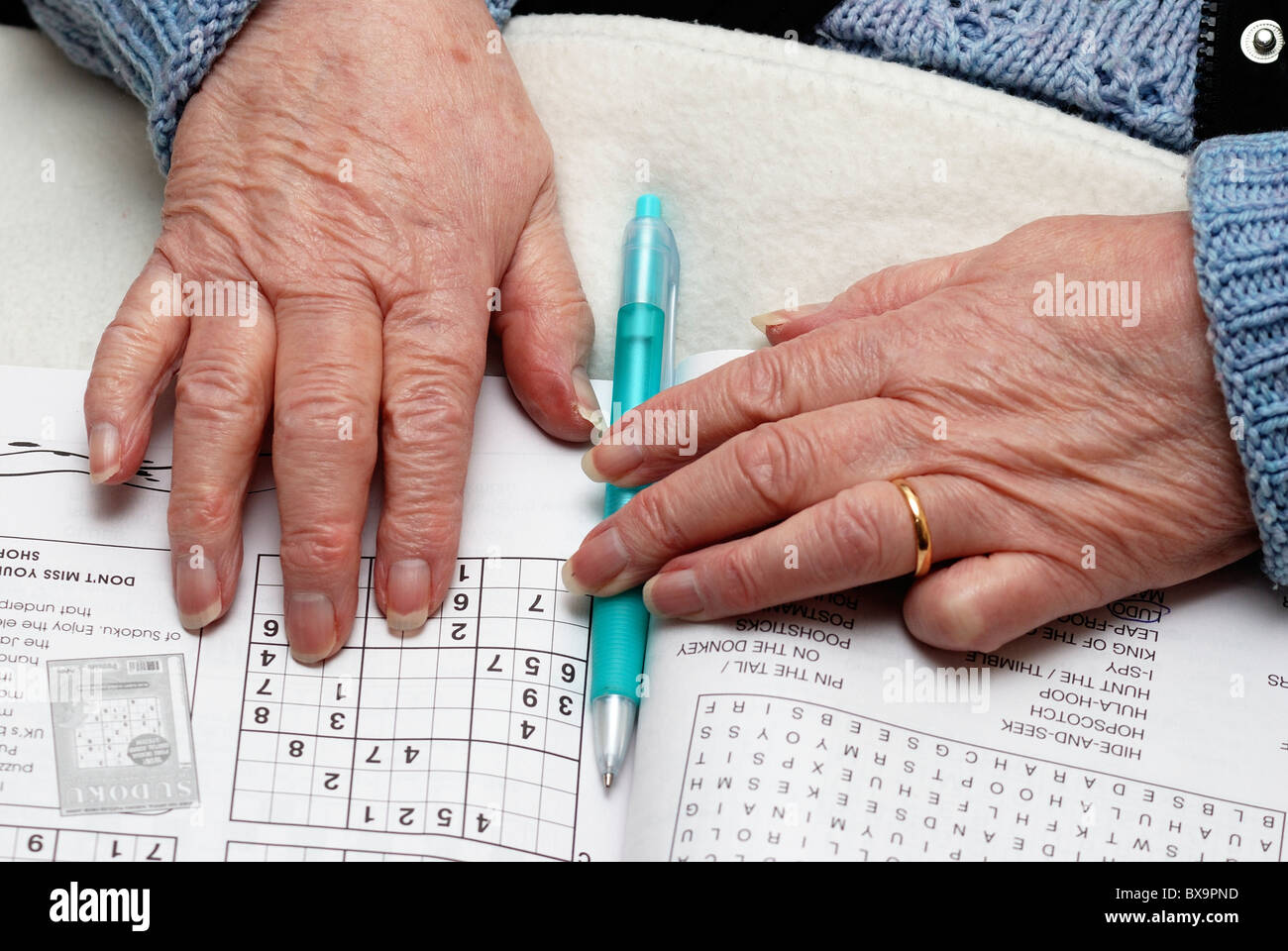 83 Jahre alte Rentnerin mit Puzzle-Buch und Stift-England-Großbritannien Stockfoto