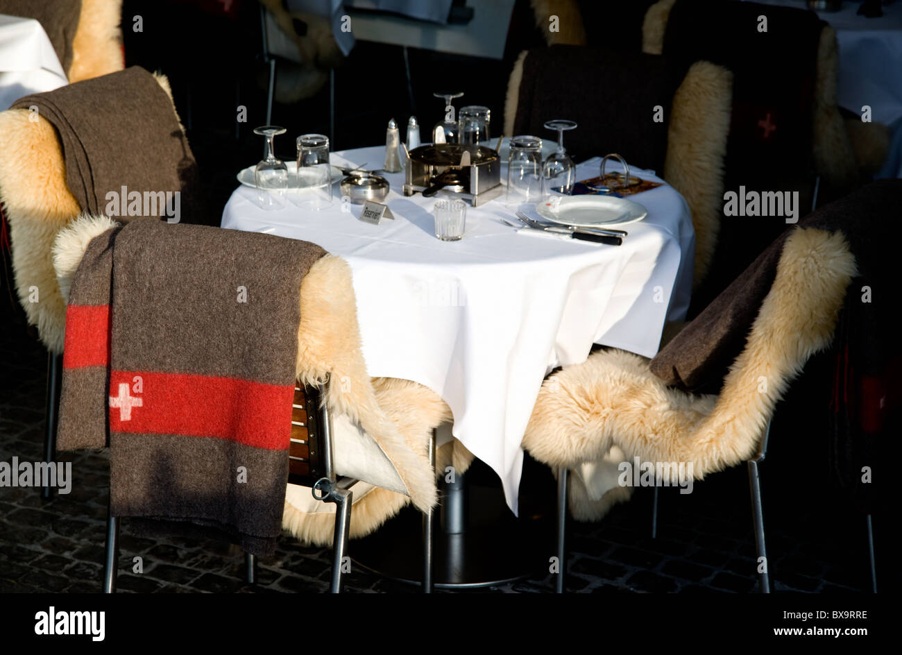 Mit Geschirr überdeckt Tisch im Restaurant mit Schweizer Armeedecken und  Fell die Stühle, in Zürich, Schweiz Stockfotografie - Alamy