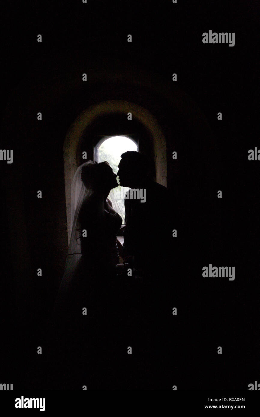 Mann und Frau dort Hochzeit Tag küssen Silhouette durch ein Fenster Stockfoto