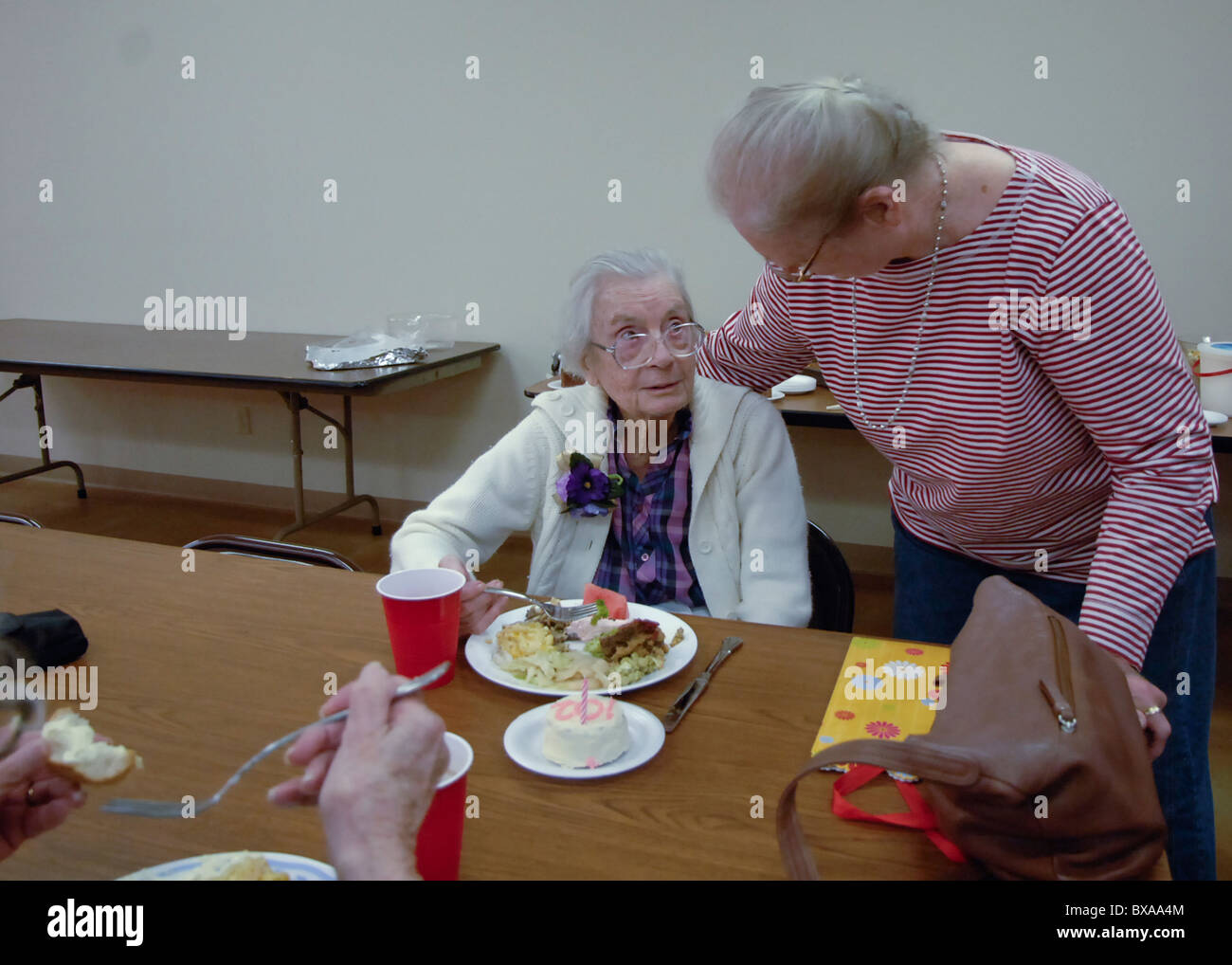 Freundin bietet Herzlichen Glückwunsch an ältere Frau an ihrem 100. Geburtstag im Rahmen eines Empfangs in ihr zu Ehren in Burnet, Texas Stockfoto