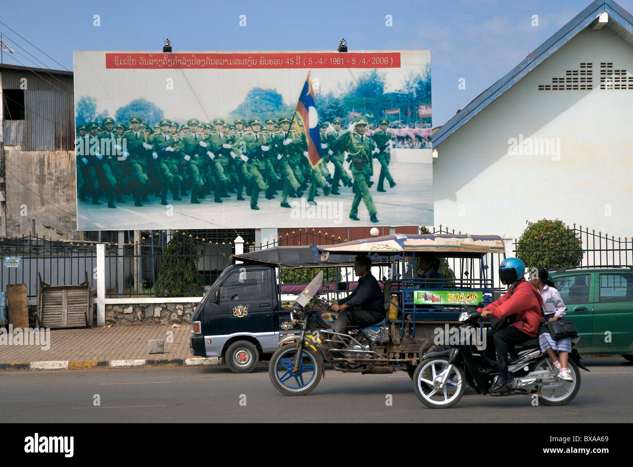 Lao Straße vor einem militärischen Propaganda-Plakat in Vientiane, Laos Stockfoto