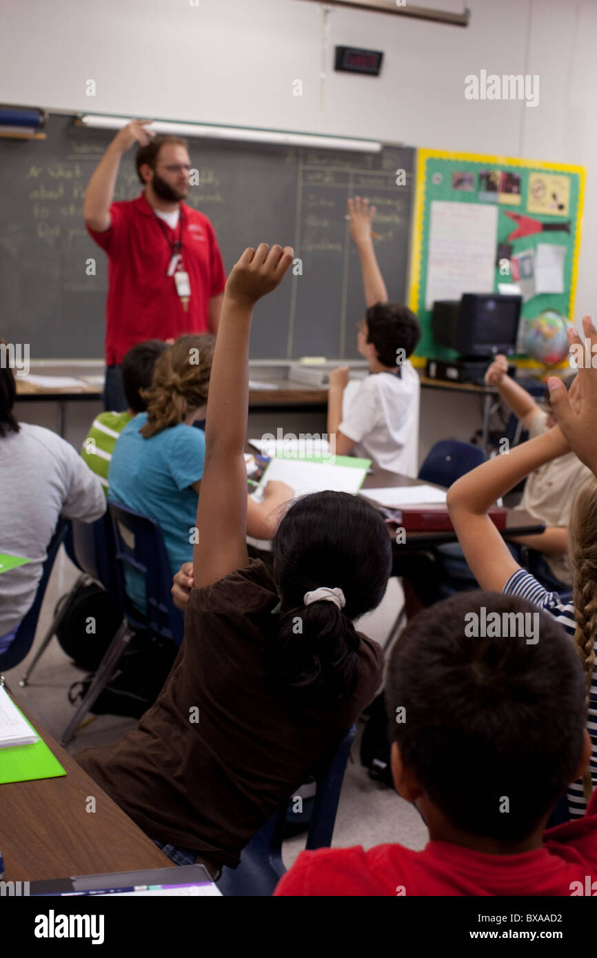 Sechsten Klasse jungen und Mädchen heben die Hände als Reaktion auf männliche Lehrer Frage in Sozialkunde Klasse Mittelschule Unterricht Stockfoto
