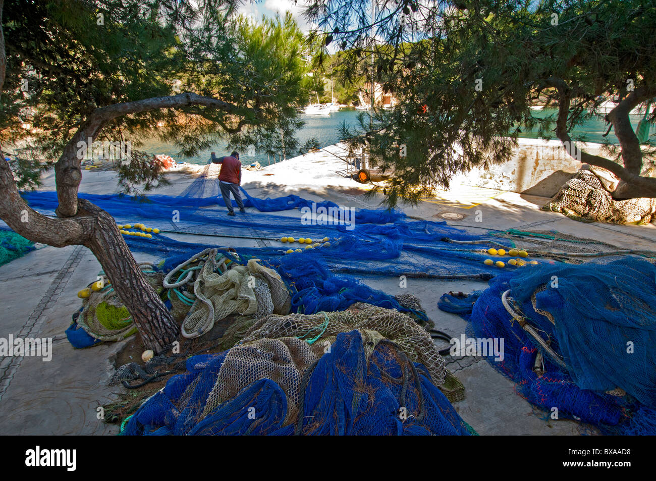 Fischer, Sortierung und Ausbessern von seinem Fischernetze in Cala Figuera Mallorca Spanien Stockfoto