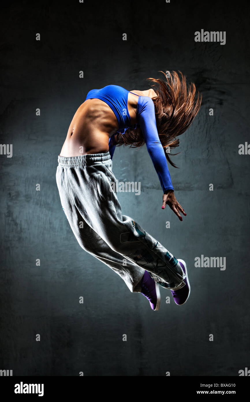 Junge Frau Tänzer springen. Auf Wand Hintergrund. Stockfoto