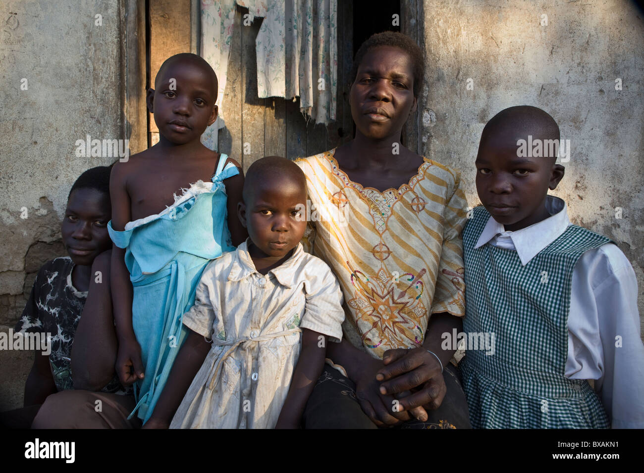 Eine HIV positiven Frau sitzt mit ihren Kindern vor ihrem Haus in Mbale, östlichen Uganda, Ostafrika. Stockfoto