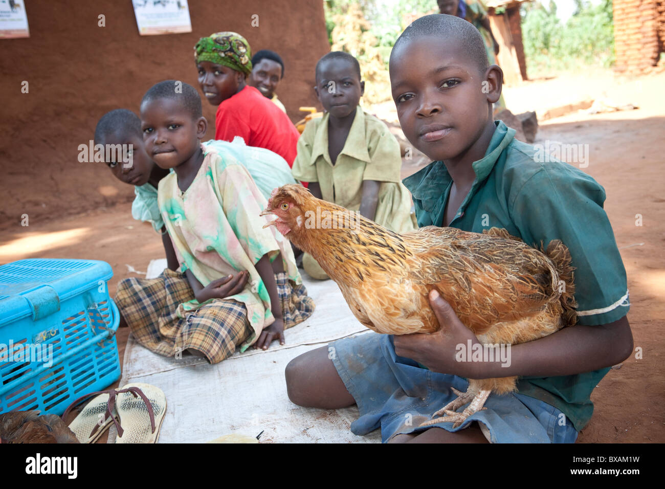 Ein Junge bringt seine Huhn in ein Gemeinschaft Impfung Tag in Nampikika Dorf, Iganga Bezirk, östlichen Uganda, Ostafrika. Stockfoto
