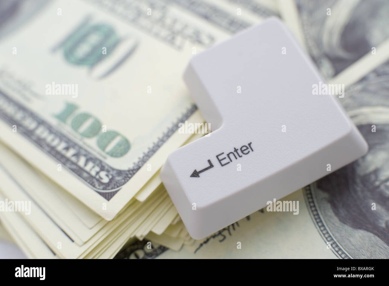 eine Enter-Taste auf einen Stapel von US-Dollar Stockfoto