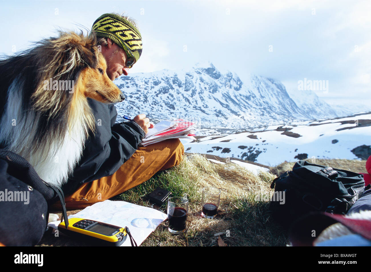 Mann mit Hund schreiben in Berglandschaft Stockfoto