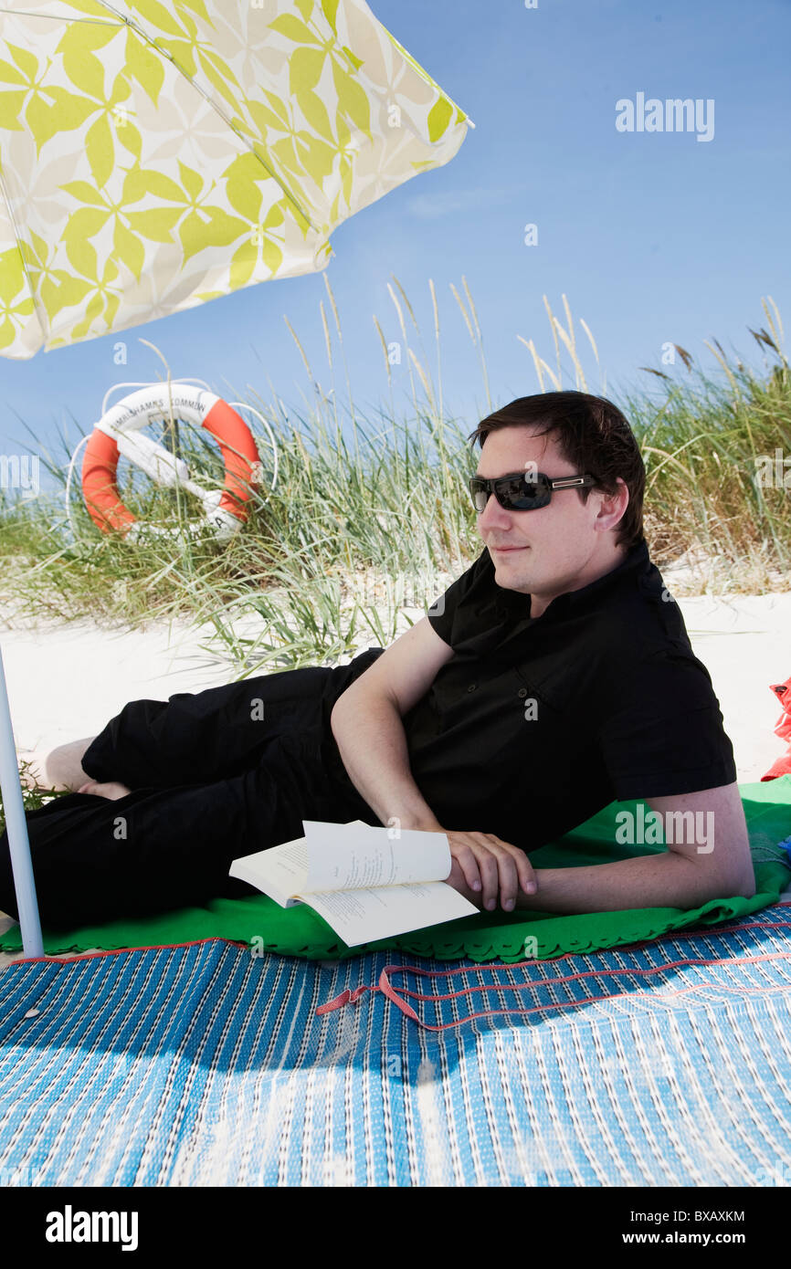 Entspannende Mann am Strand tragen Sonnenbrillen Stockfoto