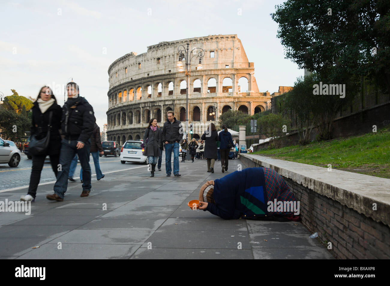 Roma, via dei Fori Imperiali mit Bettler, Passerbies und Kolosseum Stockfoto