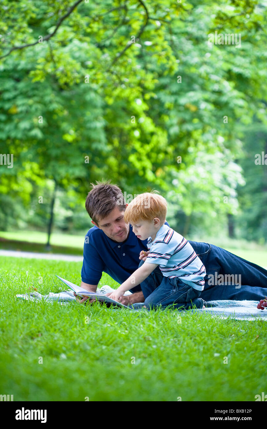 Lesebuch der Vater auf den Sohn im park Stockfoto